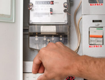 Electrical terminal box. man checking the electric control box. overload relay.